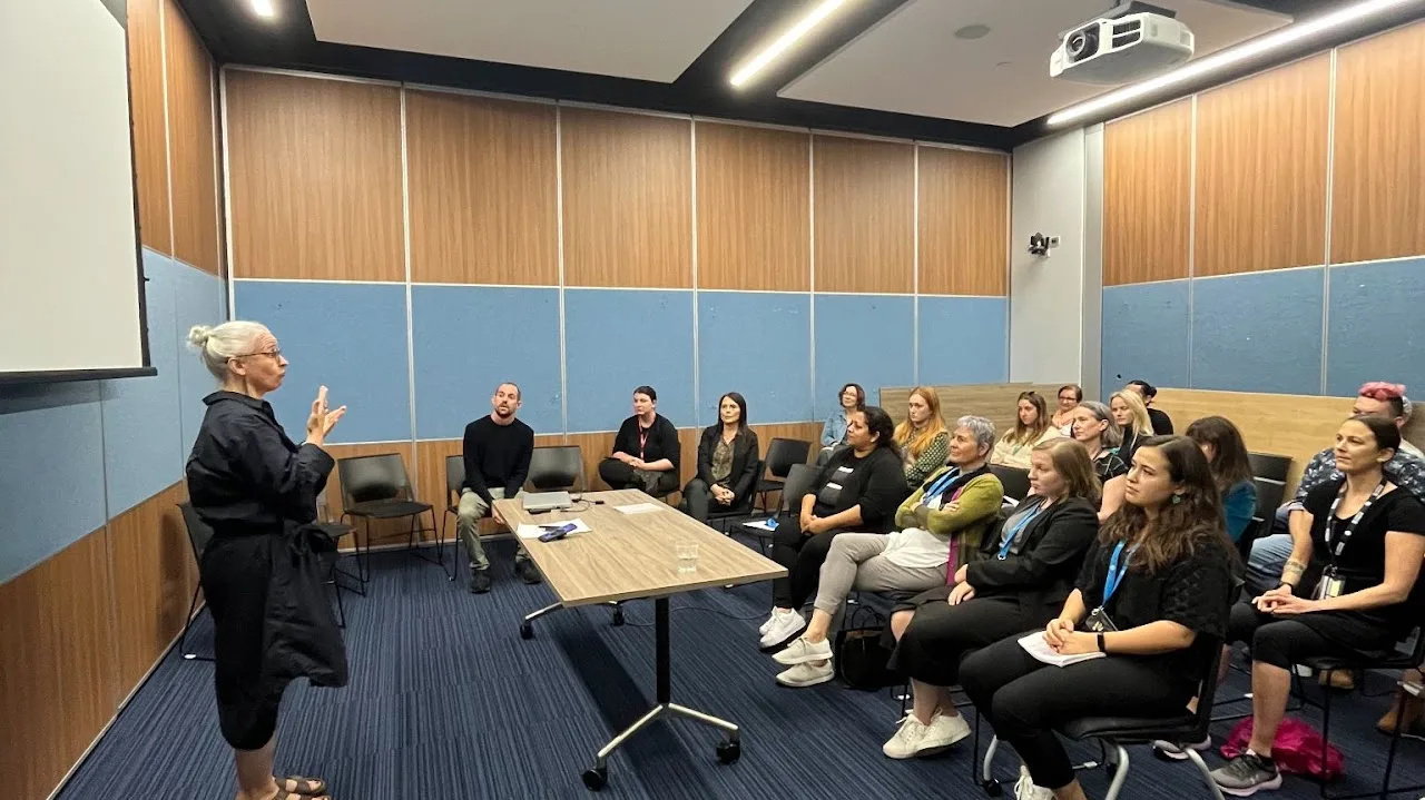 Monica signing to a seated audience of Auckland Transport staff, November 2024