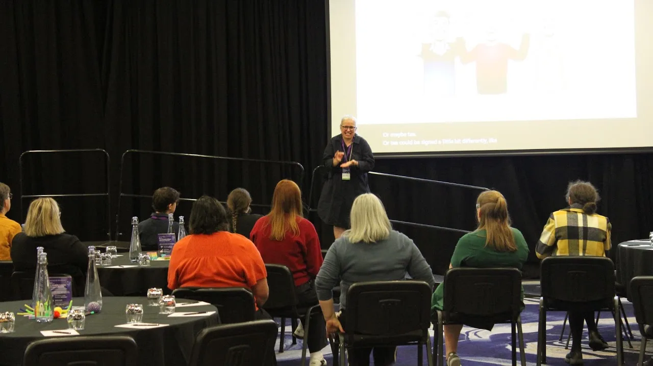Monica leading a breakfast NZSL session at the 2025 Disability Inclusive Pathways Conference, Auckland